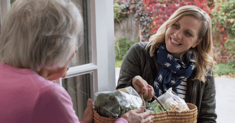 Female-Neighbor-Delivering-Groceries-to-Senior-Woman.png