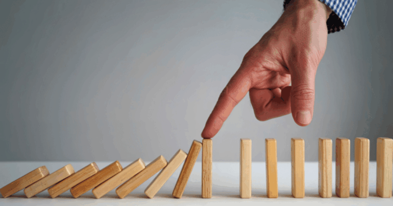Finger-pushing-dominoes-initiating-a-cascading-effect.png