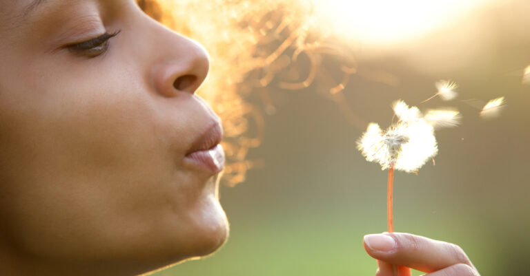16185-woman-blowing-dandelion-letting-go-of-worry-g.jpg